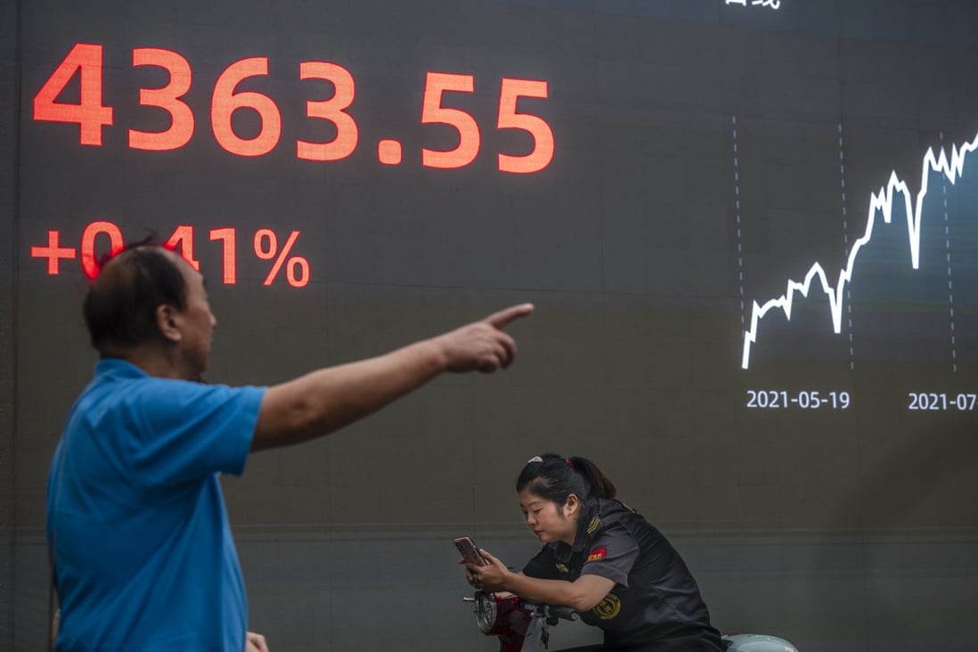 A man gestures in front of a screen showing stock exchange and economic data in Shanghai on October 7. Markets appear unconcerned about the debt woes around China Evergrande Group and several other developers, reportedly in expectation of Beijing moving to intervene. Photo: EPA-EFE