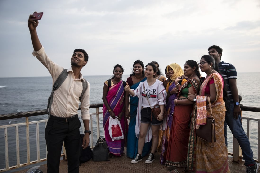 A Chinese tourist gets a picture taken with Sri Lankans on the Galle Face Green in Colombo in November 2019. Photo: Getty Images