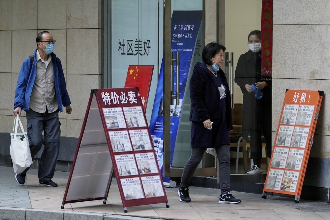 Residents walk by a property sales office in Beijing on October 5. First-time homebuyers in China could benefit as policymakers shift back towards support for the property market. Photo: AP