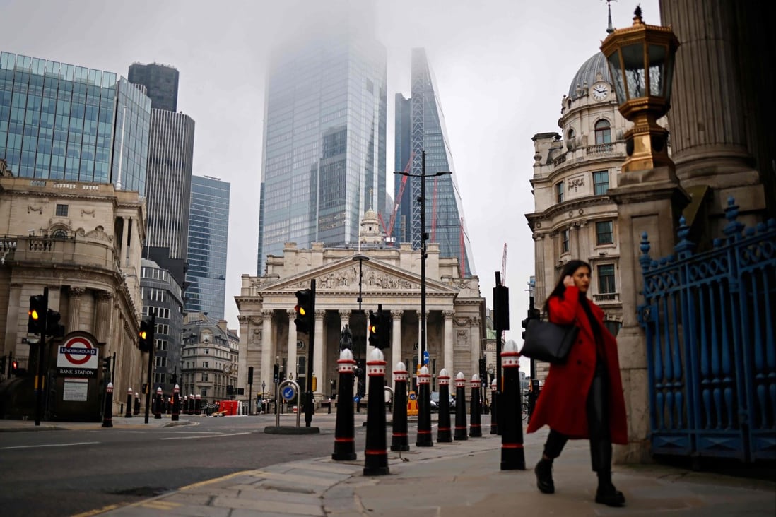 A pedestrian walks near the Royal Exchange and the Bank of England in the City of London on December 28, 2020. The central bank’s chief economist has warned that UK inflation is likely to hit or surpass 5 per cent by early next year. Photo: AFP