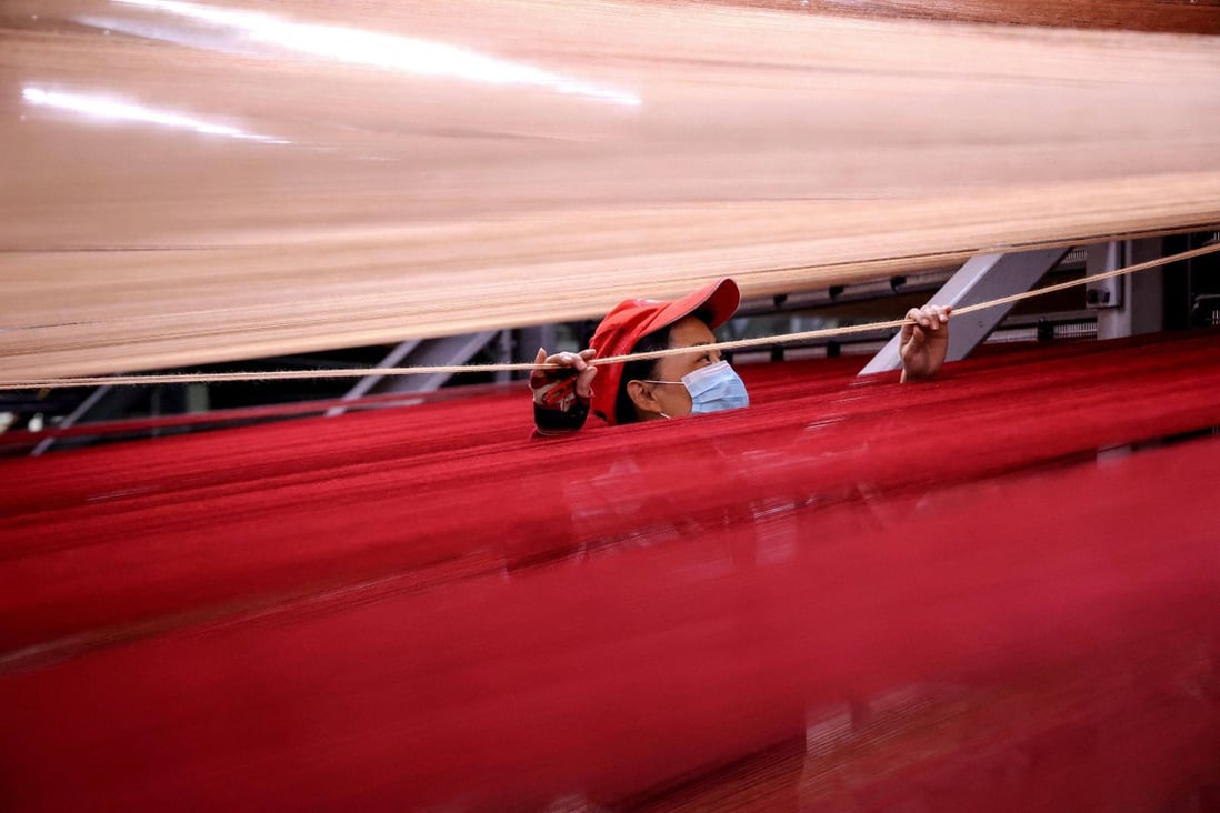 A worker makes carpets for export at a factory in Binzhou, in China’s eastern Shandong province, on October 20. A steep deceleration in Chinese growth would be a shock to a world accustomed to annual rates in excess of 7 per cent for most of the past 20 years. Photo: AFP