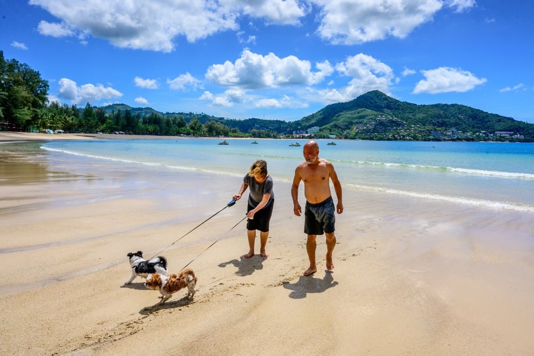 Tourists walk their dogs on a beach on the Thai island of Phuket on November 1 as Thailand welcomes the first group of travellers fully vaccinated against the Covid-19 coronavirus without quarantine. Photo: AFP
