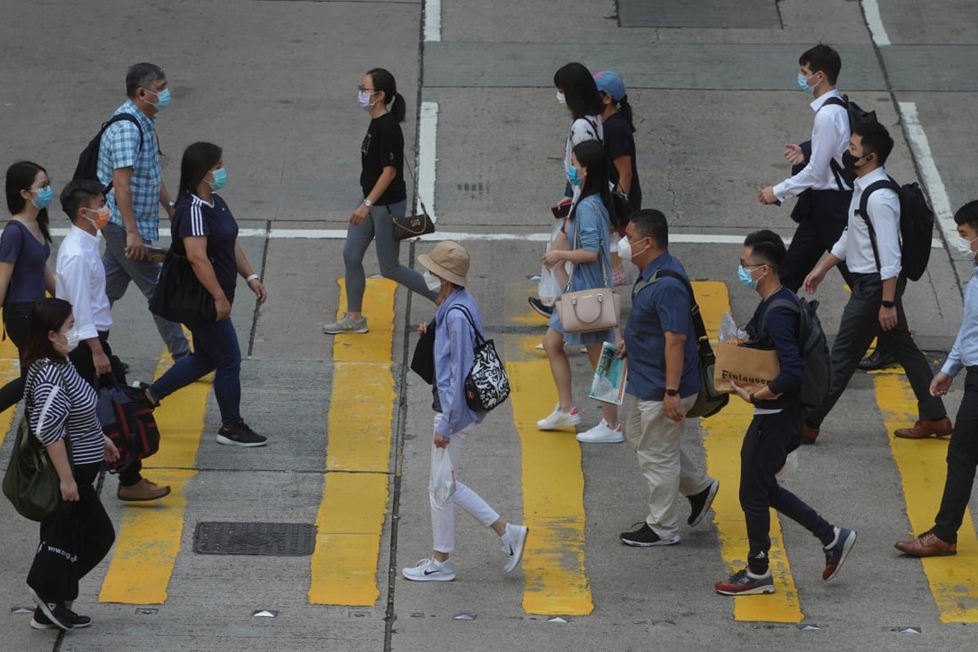 People cross a road in Central. Hong Kong’s workforce continues to contract, to around 3.84 million, down from a peak of 3.97 million in the spring of 2019. Photo: Winson Wong