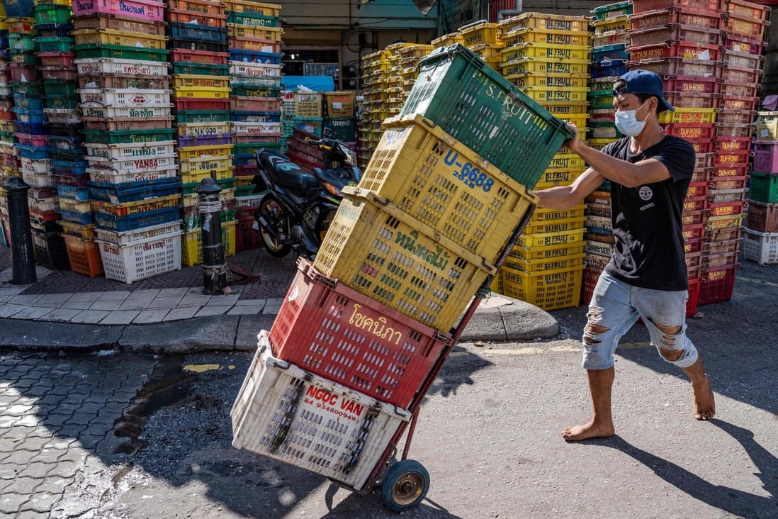 A worker pushes empty crates at a fruit market in Kuala Lumpur. Photo: AFP 