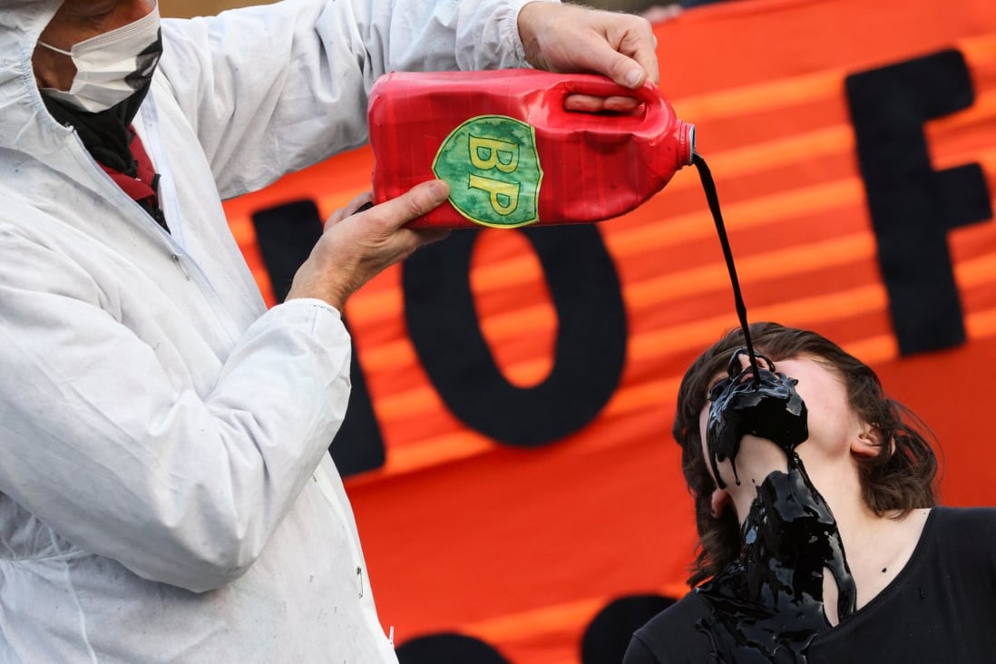 A man pours fake fuel on the face of a protester during a demonstration against the fossil fuel industry during the UN Climate Change Conference in Glasgow, Scotland, on November 7. Photo: Reuters