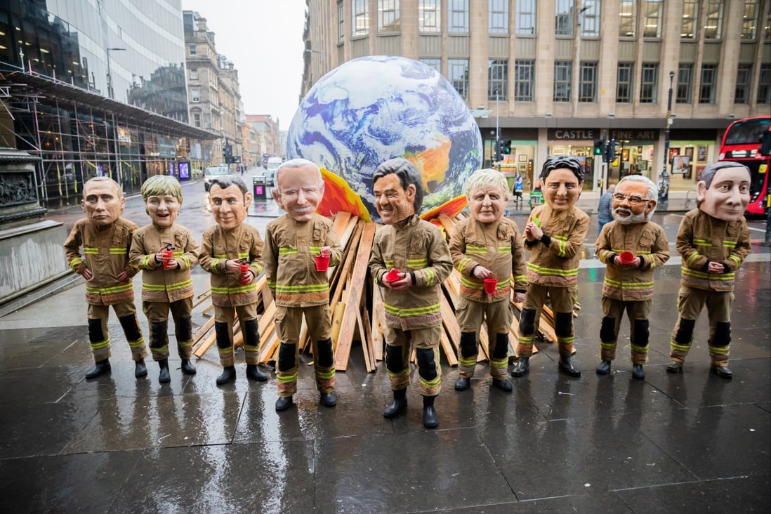 Activists dressed as world leaders in firefighter costumes stand in front of a model representing the globe on a pyre, during an Oxfam protest in conjunction with the COP26 UN Climate Change Conference, in Glasgow on November 12. Photo: dpa