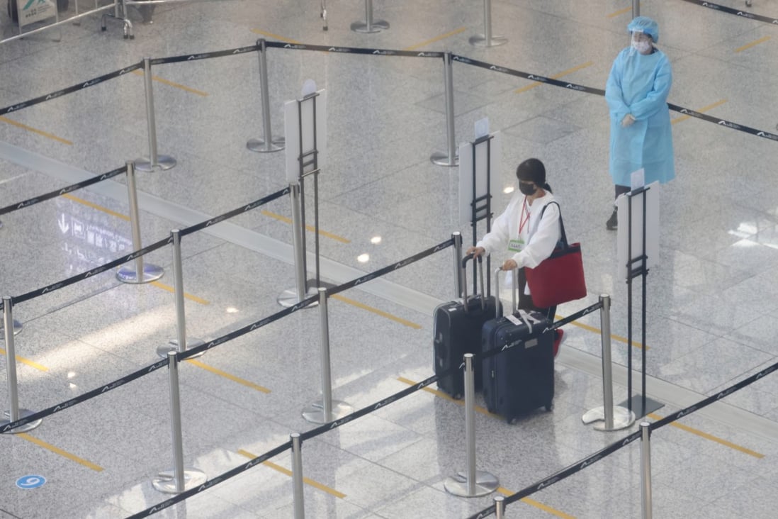 A traveller arriving at Hong Kong airport on November 14 waits in line for transport to a quarantine hotel. Photo: May Tse