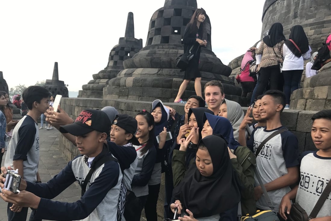 A foreigner is swarmed by school children at Indonesia’s Borobudur temple. Photo: Resty Woro Yuniar