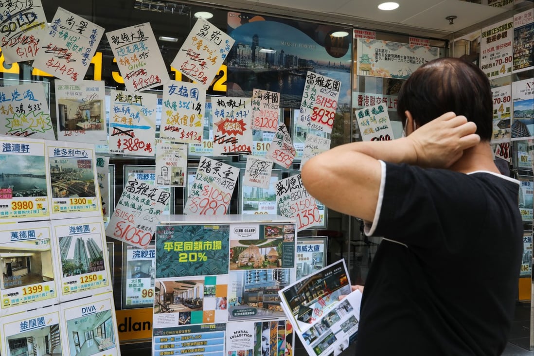 A potential customer looks at ads in the window of a property agency office in North Point, Hong Kong. Photo: Nora Tam