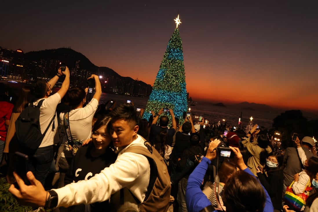Hong Kong residents take photos of Christmas decorations at the waterfront promenade in West Kowloon Cultural District. The Hospital Authority has advised people to get vaccinated against the seasonal flu as the weather turns cooler. Photo:  Nora Tam