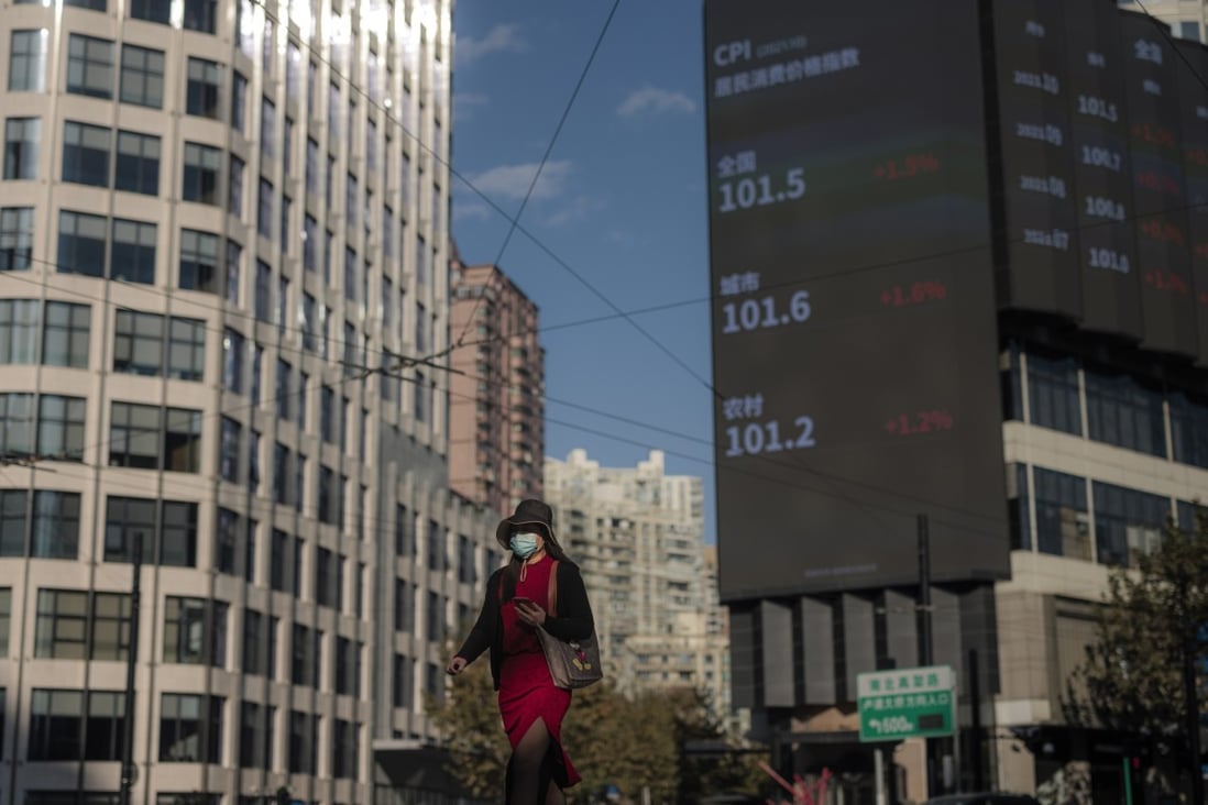 A woman walks on the street next to a large screen showing the Shanghai stock exchange data. Photo: EPA-EFE