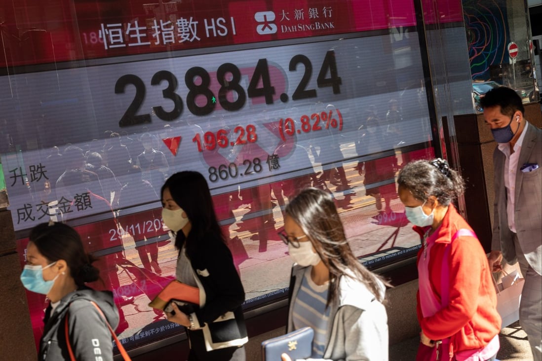People walk past an electronic board displaying the Hang Seng Index on November 29. Photo: EPA-EFE
