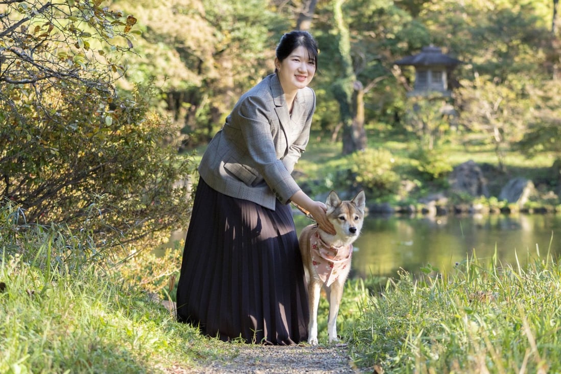 Japan’s Princess Aiko with her pet dog in the garden of the Imperial Residence in Tokyo ahead of her 20th birthday. Photo: The Imperial Household Agency of Japan via AP