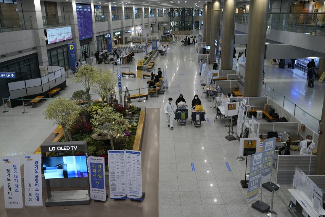 A quarantine officer guides travellers at the arrival hall of the Incheon airport in South Korea on Wednesday. Photo: AP
