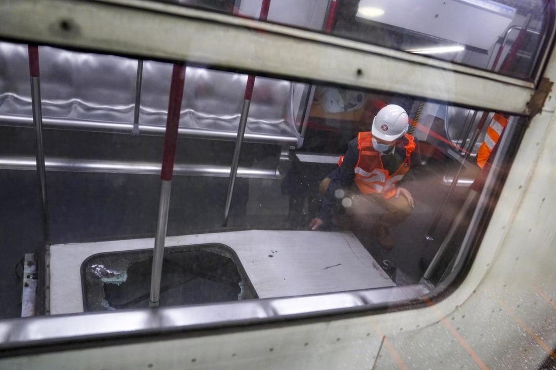 An MTR worker examines one of the detached doors after it was recovered and hauled back aboard the train. Photo: Sam Tsang