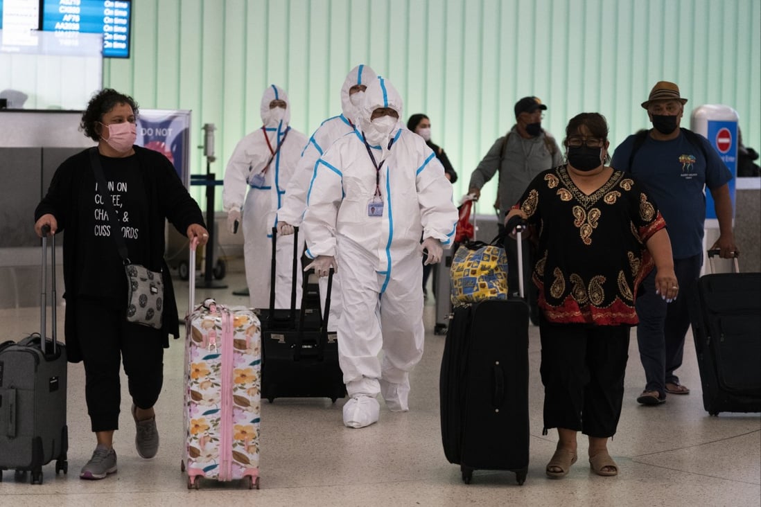 Air China flight crew members in hazmat suits walk through the arrivals area at Los Angeles International Airport in Los Angeles, Tuesday, Nov. 30, 2021. Photo: AP
