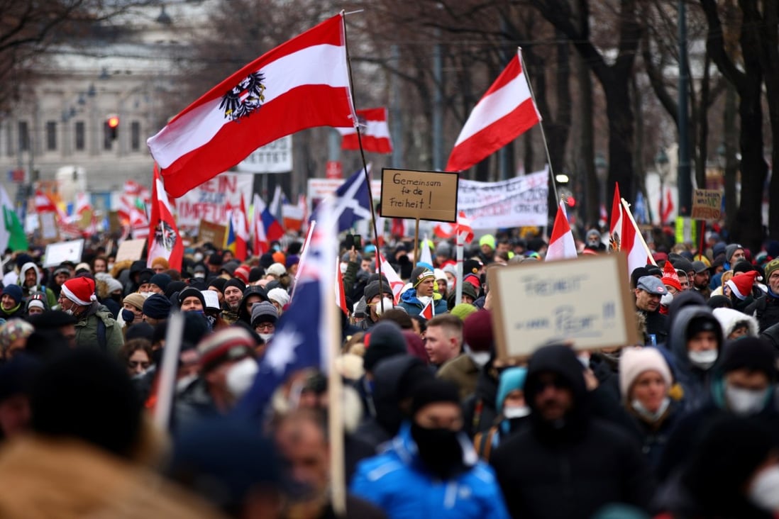 Protesters hold flags and placards as they march against coronavirus restrictions and the mandatory vaccination in Vienna, Austria on Saturday. Photo: Reuters 