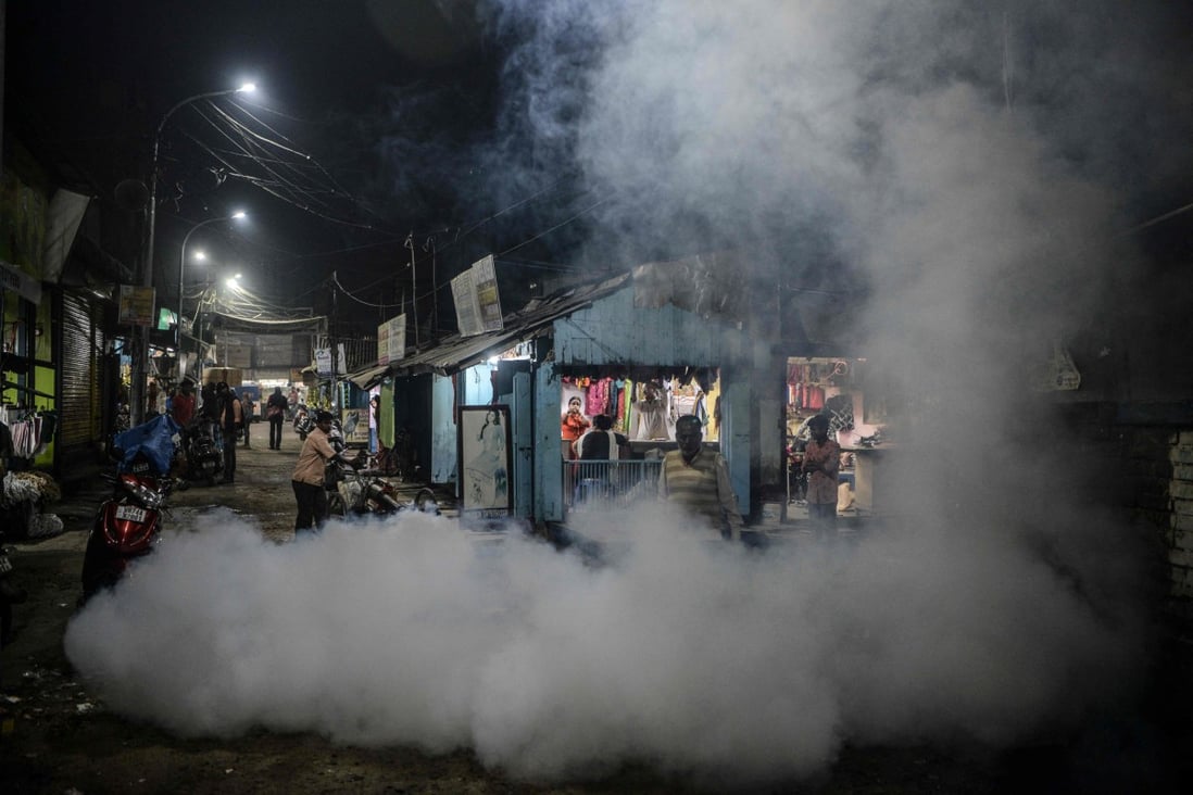 A municipal worker fumigates a market area as preventive measure against mosquito-born diseases in Siliguri, India. Photo: AFP
