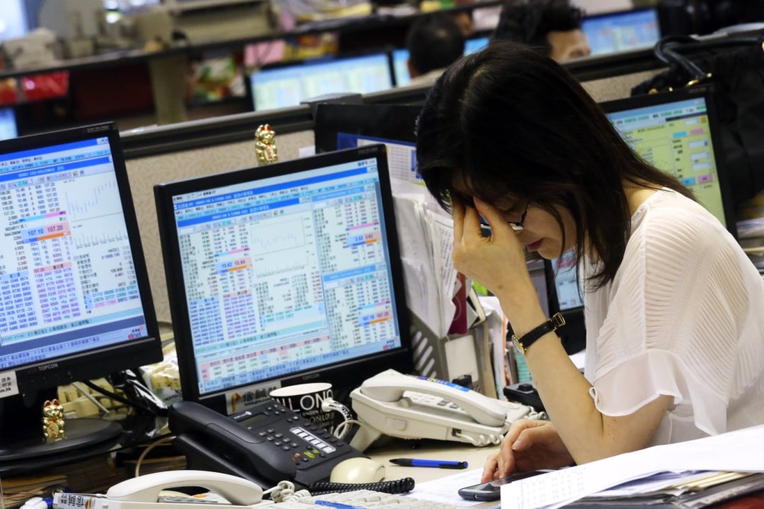 A stock trader looking at the market prices at a brokerage in Central Hong Kong. Photo: SCMP