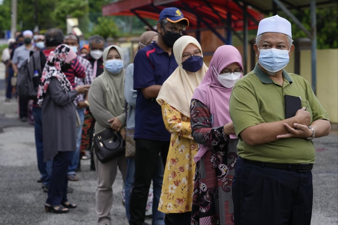Voters wearing face masks line up to enter a voting centre on the outskirts of Malacca, Malaysia. Photo: AP