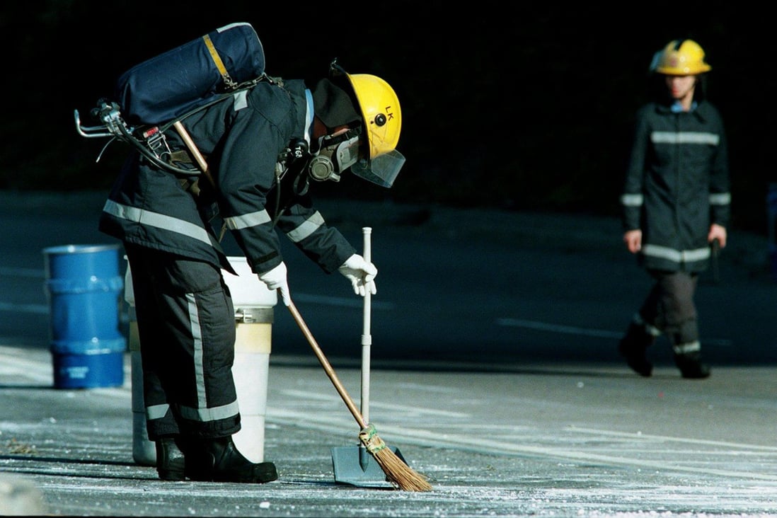 Firemen in protective gear clean up barrels of lethal sodium cyanide spilled on a road in Tai Po, Hong Kong, following an accident near the Kowloon Reservoirs in December 1997. Photo: SCMP