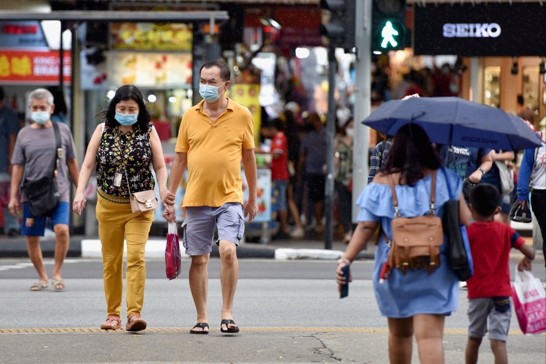 People cross a road in Singapore. Photo: Reuters