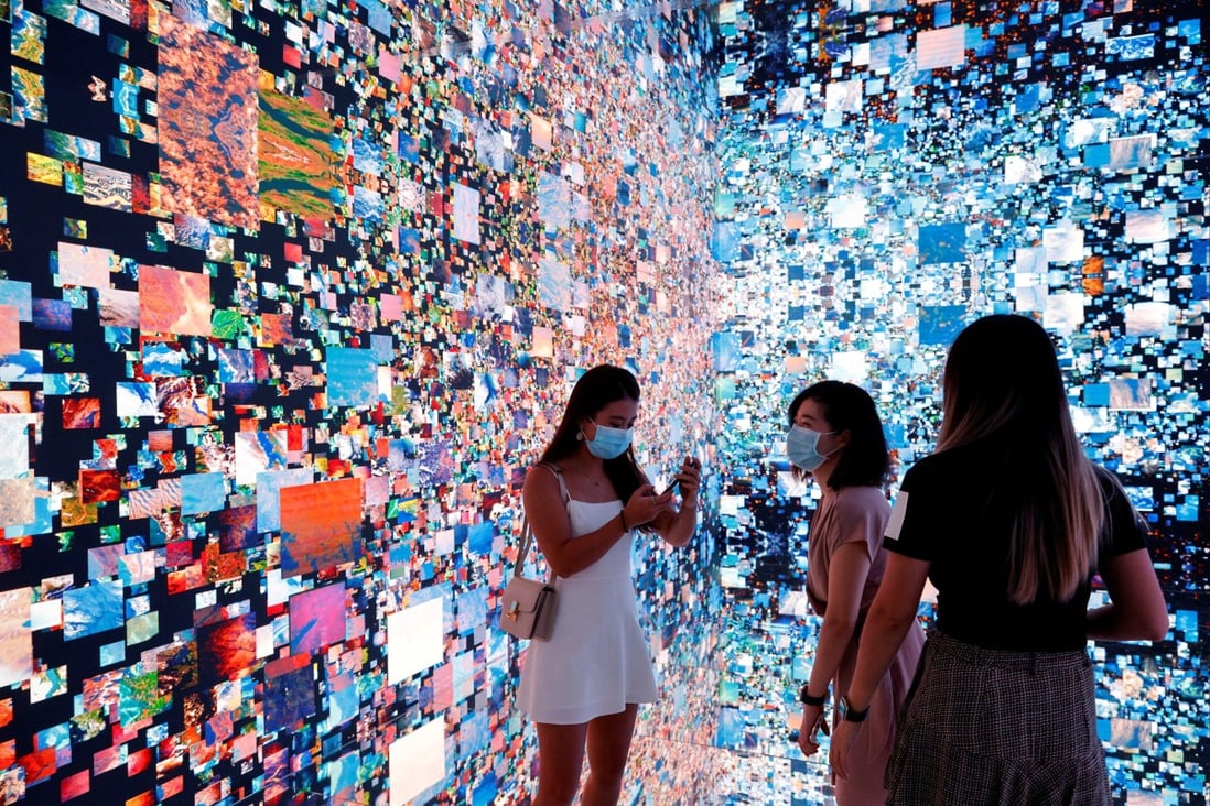 Visitors pictured in front of an immersive art installation titled “Machine Hallucinations — Space: Metaverse” by media artist Refik Anadol, which will be converted into NFT and auctioned online at Sotheby’s, at the Digital Art Fair in Hong Kong on September 30. Photo: Reuters