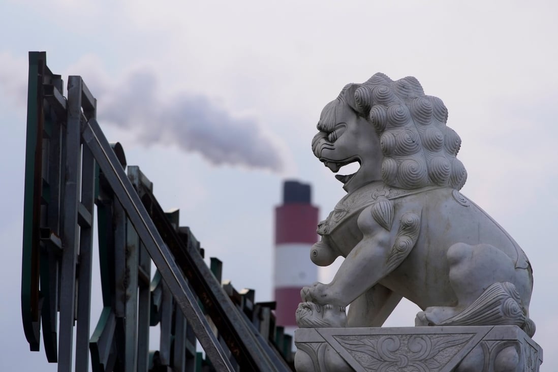 The chimney of a coal-fired power plant stands behind a lion statue in Shanghai, China. Photo: Reuters