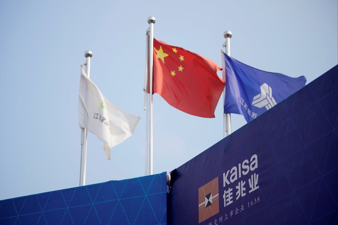 The Kaisa logo is seen in front a Chinese flag at a construction site that is being developed by the group in Shanghai. Photo: Reuters