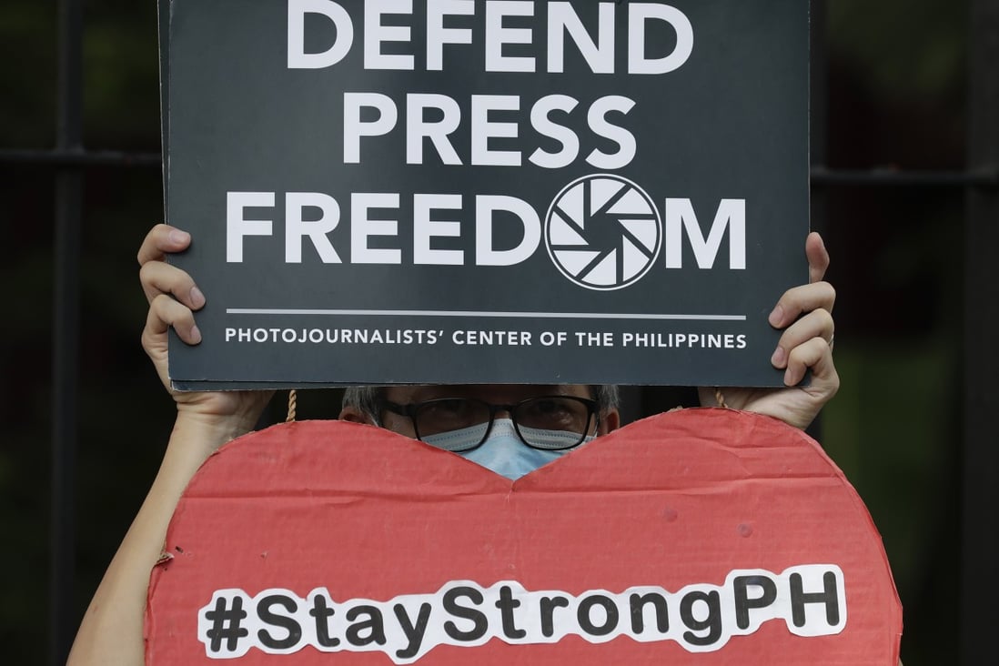 A journalist holds a sign during a 2020 protest about media freedom in the Philippines. Photo: AP