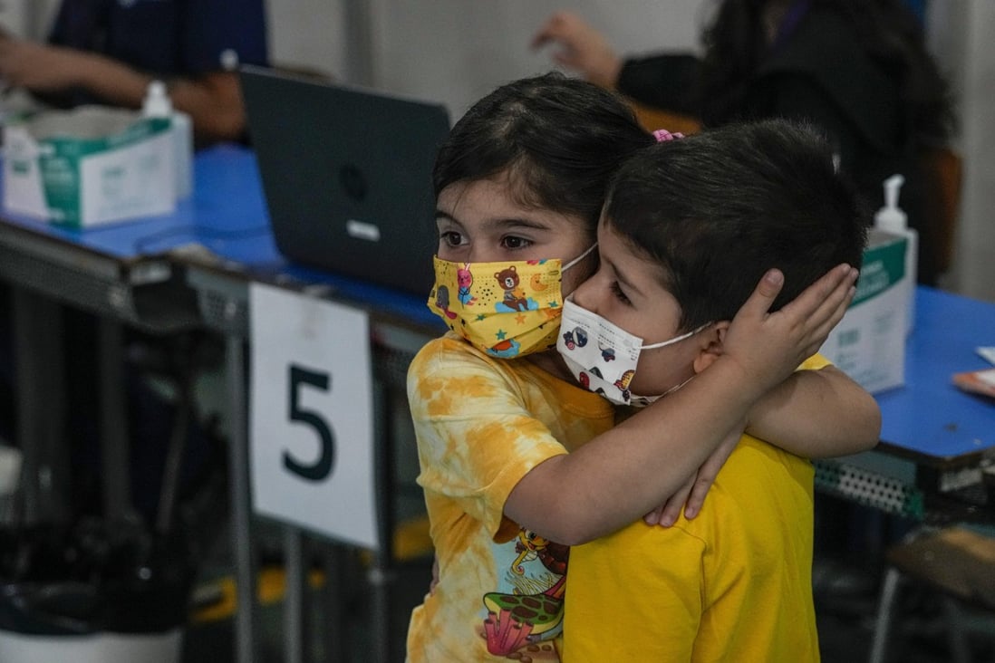 Six-year-old Emilia Gutierrez comforts her brother Vicente before he was to get his first Sinovac jab in Santiago, Chile on Monday. Chile is one of the 57 countries in which the Omicron variant has been detected. Photo: AP