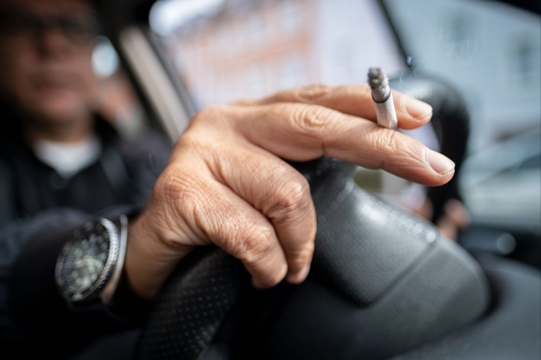 A man smokes a cigarette as he holds the steering wheel. New Zealand’s proposed legislation to curb smoking has been described as a ‘game-changer’. Photo: DPA