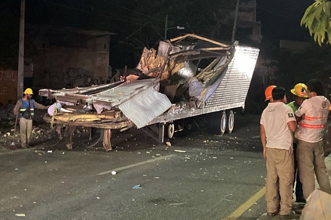 Workers remove the container from the trailer of a truck that crashed with migrants aboard in Chiapas state, Mexico, killing dozens. Photo: AFP