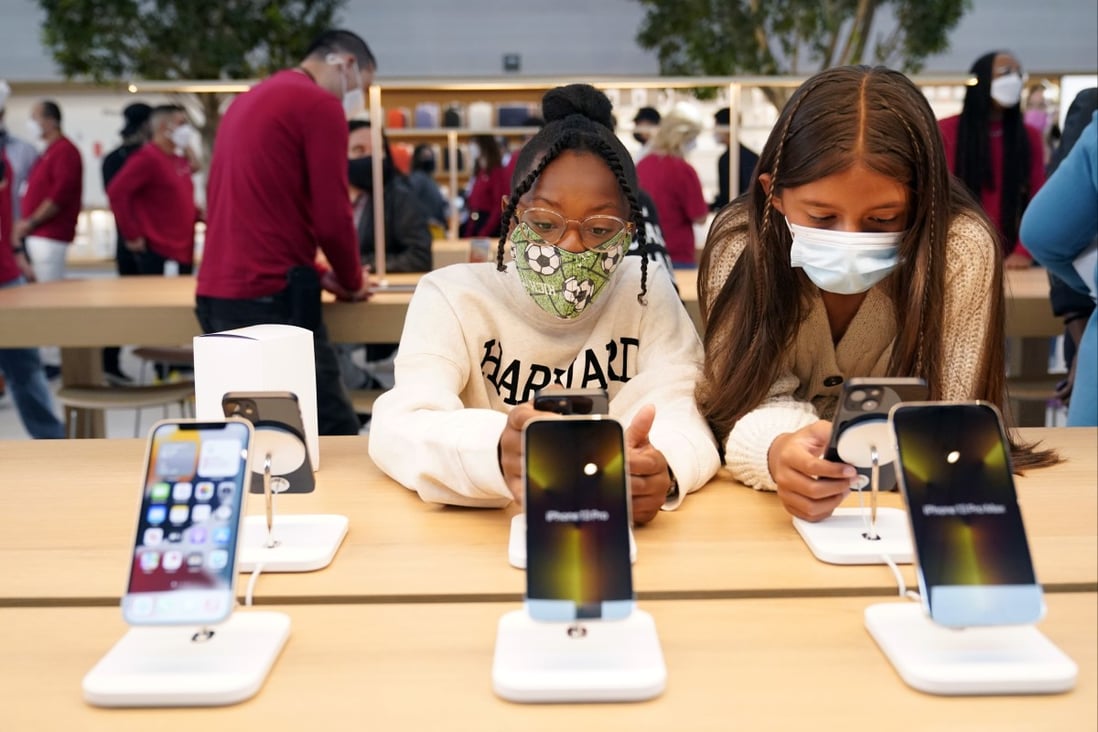 Young customers looks at iPhones at an Apple Store in Los Angeles in November. Photo: AP