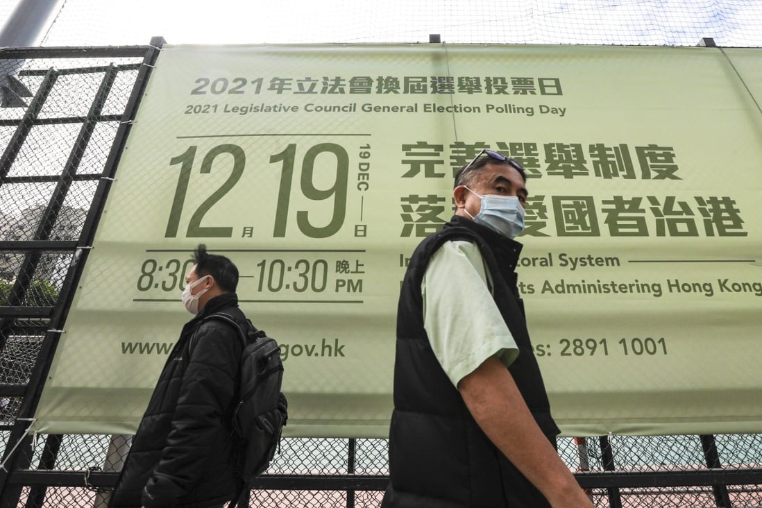 People walk past a banner of the coming Legco election. Photo: Felix Wong