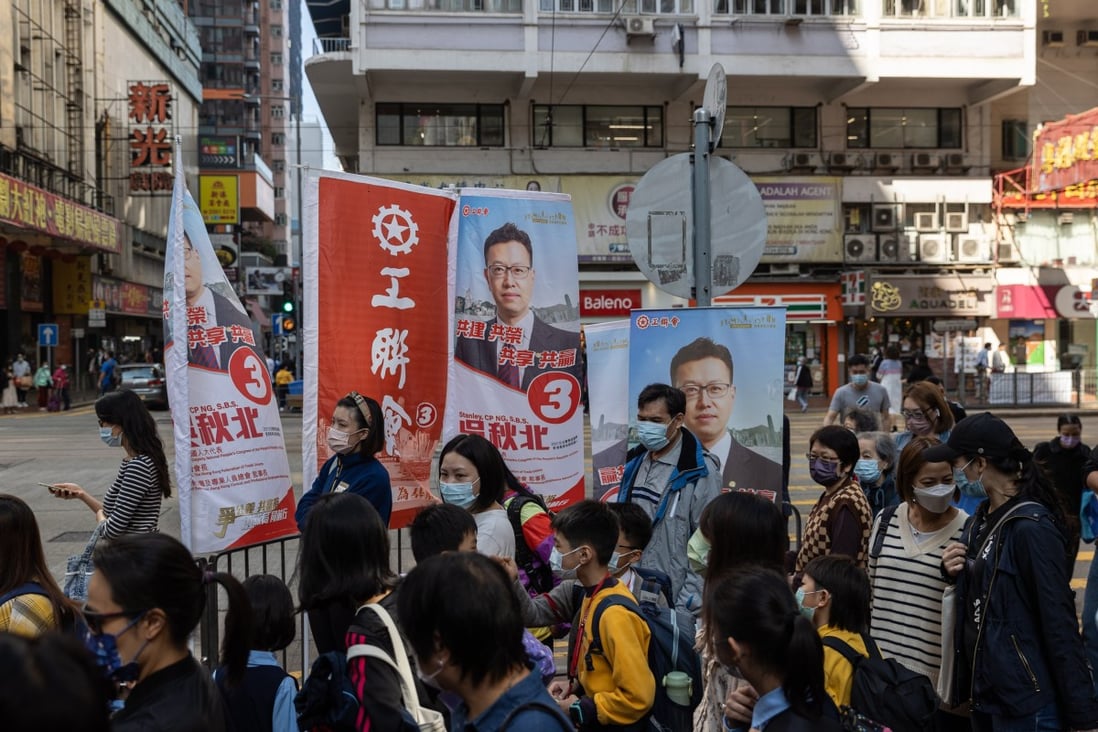 Pedestrians walk past election posters in Hong Kong on December 14. Hong Kong will hold its Legislative Council election on Sunday, the first since Beijing revamped the electoral system to ensure that only patriots can hold political power. Photo: EPA-EFE