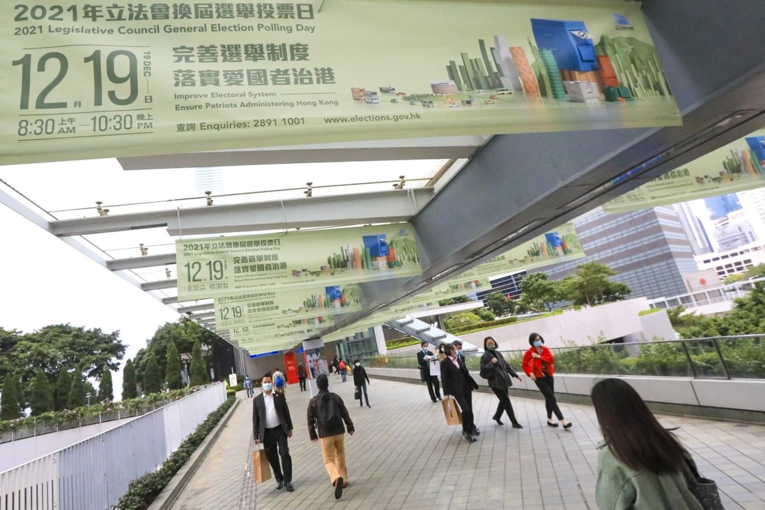 Pedestrians in Admiralty pass under banners promoting the Legislative Council election on Sunday. Photo: Felix Wong