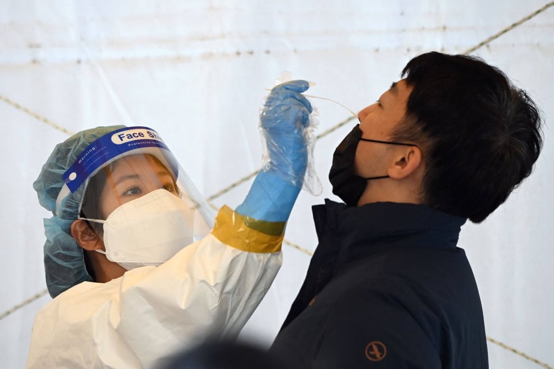 A nurse takes a nasal swab from a man at a Covid-19 testing centre in Seoul, as cases in South Korea reached record levels. Photo: AFP