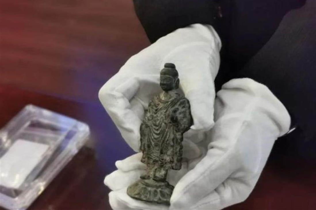 Two alloy Buddha statues were found in a tomb chamber that dates back to the Eastern Han dynasty. Photo: Xinhua