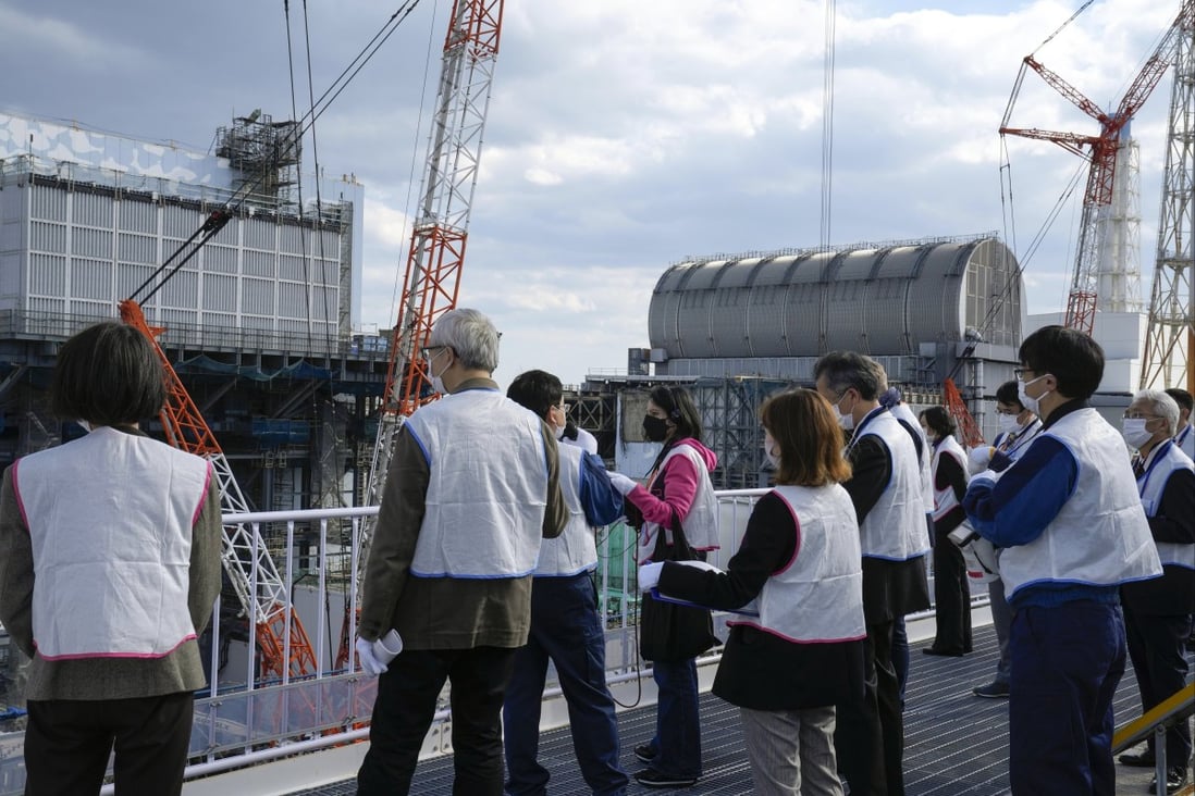 Visitors watch as decommissioning work at the Fukushima power plant takes place on November 15, 2021. Photo: EPA-EFE