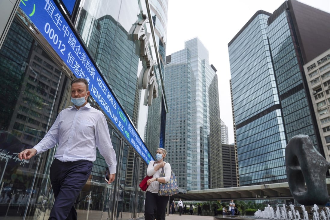 People walk past electronic tape displaying stock prices at the Exchange Square in Central, Hong Kong in October 2021. Photo: Sam Tsang