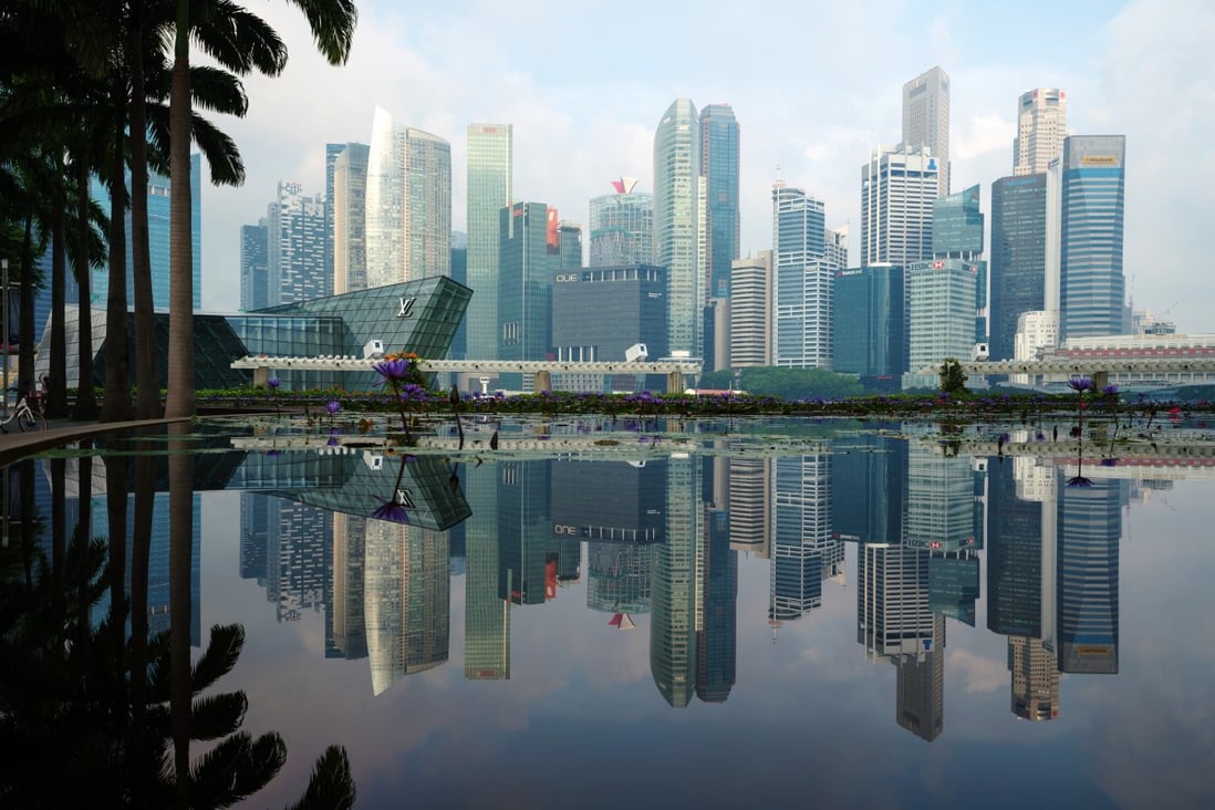 Commercial buildings in the central business district are reflected on a pond in Singapore, on June 3, 2018. Photo: Bloomberg