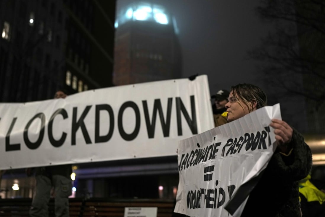 A protester holds a banner during an anti-coronavirus restriction demonstration in the Hague, the Netherlands on December 18. Photo: AP