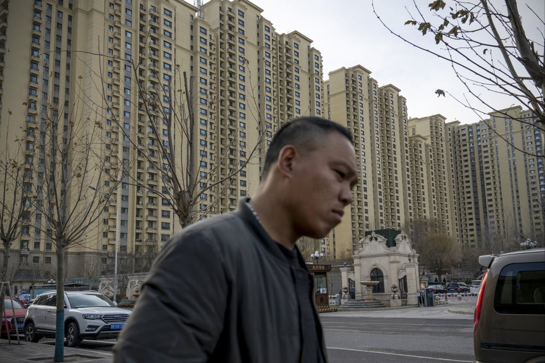 A pedestrian walks past apartment buildings at the City Plaza development of the highly indebted China Evergrande Group in Beijing. Photo: Bloomberg
