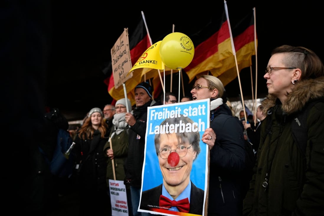 Protesters hold a banner with an image of Germany’s Health Minister Karl Lauterbach reading “Freedom instead of Lauterbach” in Duesseldorf, Germany on Saturday. Photo: AFP