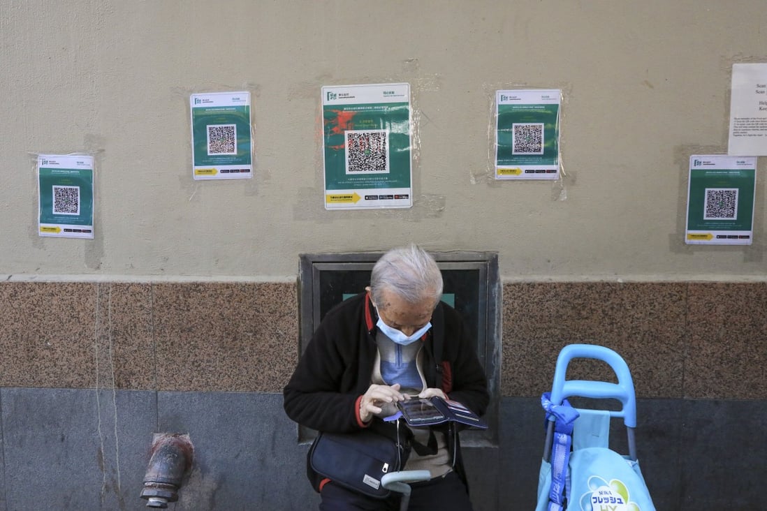 An elderly Hong Kong resident uses the government’s “Leave Home Safe” app in Sham Shui Po. Photo: Felix Wong