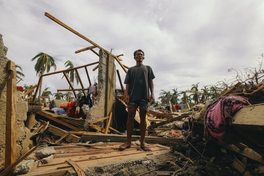 A man stands on his damaged house after Typhoon Rai hit Surigao City, southern Philippines. Photo: AP