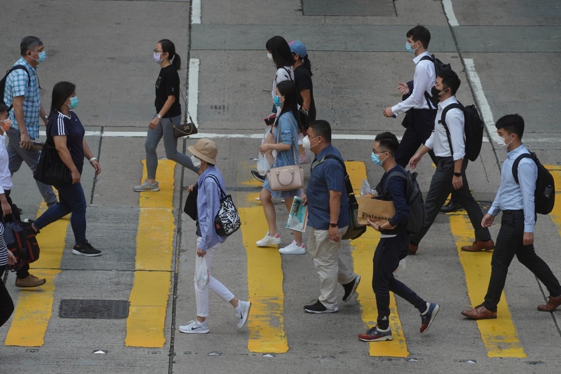 People cross a road in Central on October 21. 
With the global job market becoming more competitive, some young people in Hong Kong are taking up different jobs simultaneously. Photo: Winson Wong