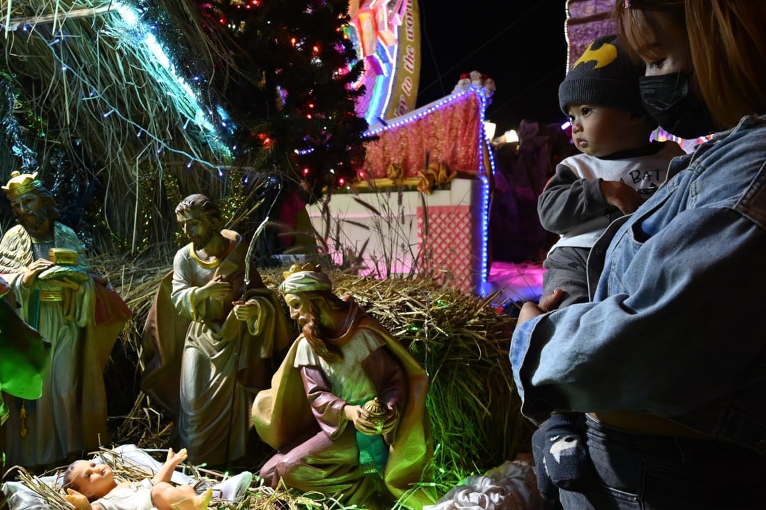 A mother and her child look at a nativity scene during the Tha Rae star parade in Thailand’s Sakon Nakhon province on Thursday. Photo: Vivat Thongantang