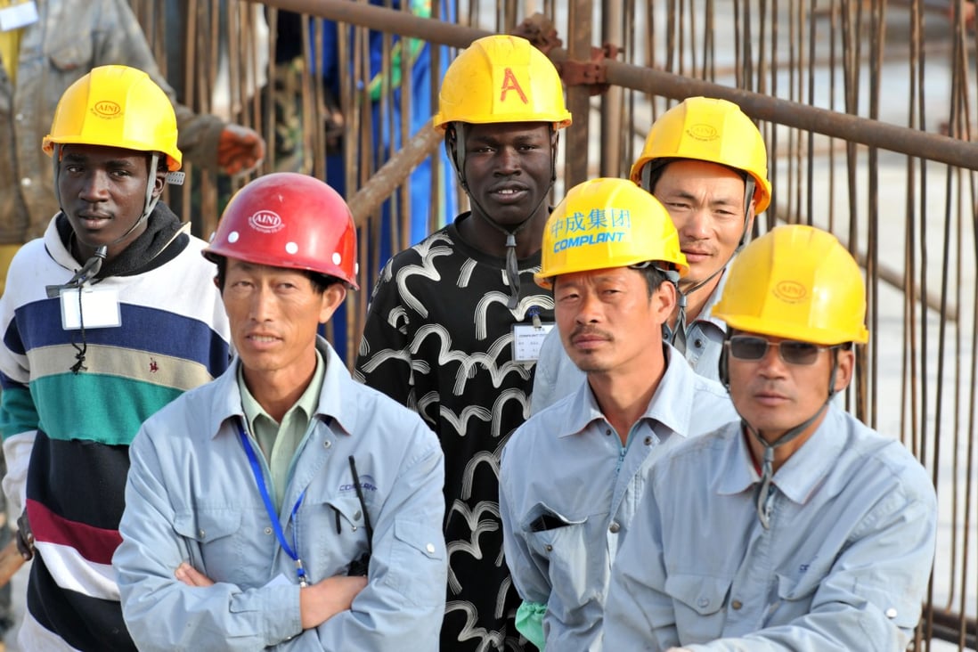 Senegalese and Chinese workers observe a ceremony at a construction project financed by China. Photo: AFP